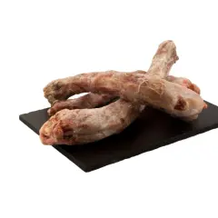 Surowe szyje z indyka na czarnej desce. Czy pies może jeść szyje z indyka? Tak, to naturalny przysmak dla psa.