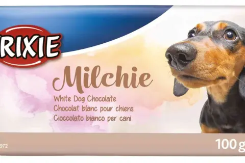 Pies może jeść białą czekoladę "Milchie" od Trixie. Opakowanie z pieskiem jamnikiem i informacją o produkcie.