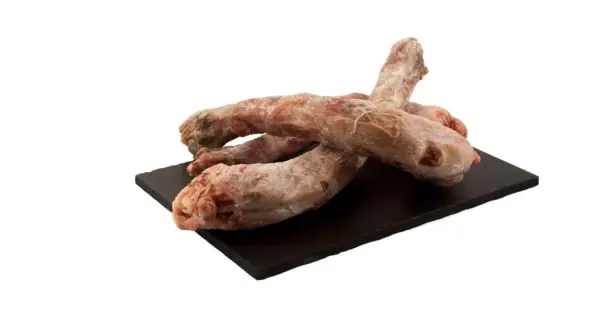 Surowe szyje z indyka na czarnej desce. Czy pies może jeść szyje z indyka? Tak, to naturalny przysmak dla psa.