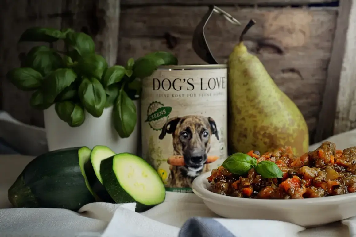 Czy pies może jeść rosół? Puszka "Dog's Love" z psem i marchewką, obok cukinia, gruszka i miseczka z jedzeniem.