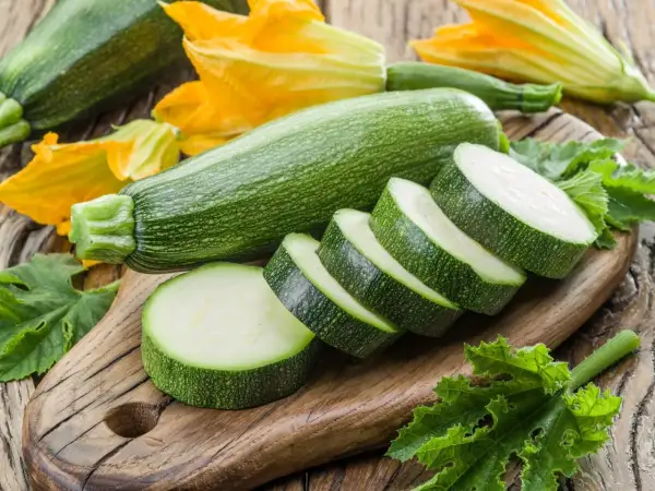 Świeże cukinie i kwiaty na desce. Czy pies może cukinie? Tak, w małych ilościach, ale lepiej zapytać weterynarza.